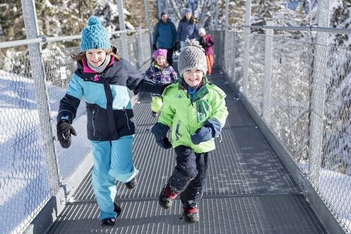 Familie im Winter auf der Hängebrücke.