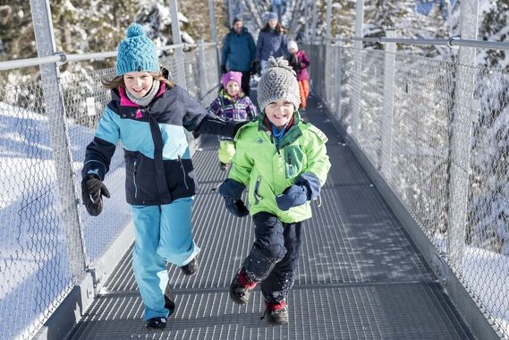 Familie im Winter auf der Hängebrücke.