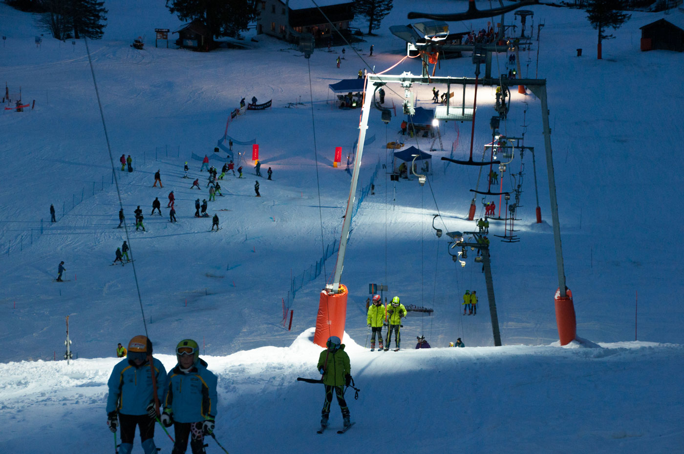 Skilift Engelstock bei Nachbeleuchtung mit Skifahrern.