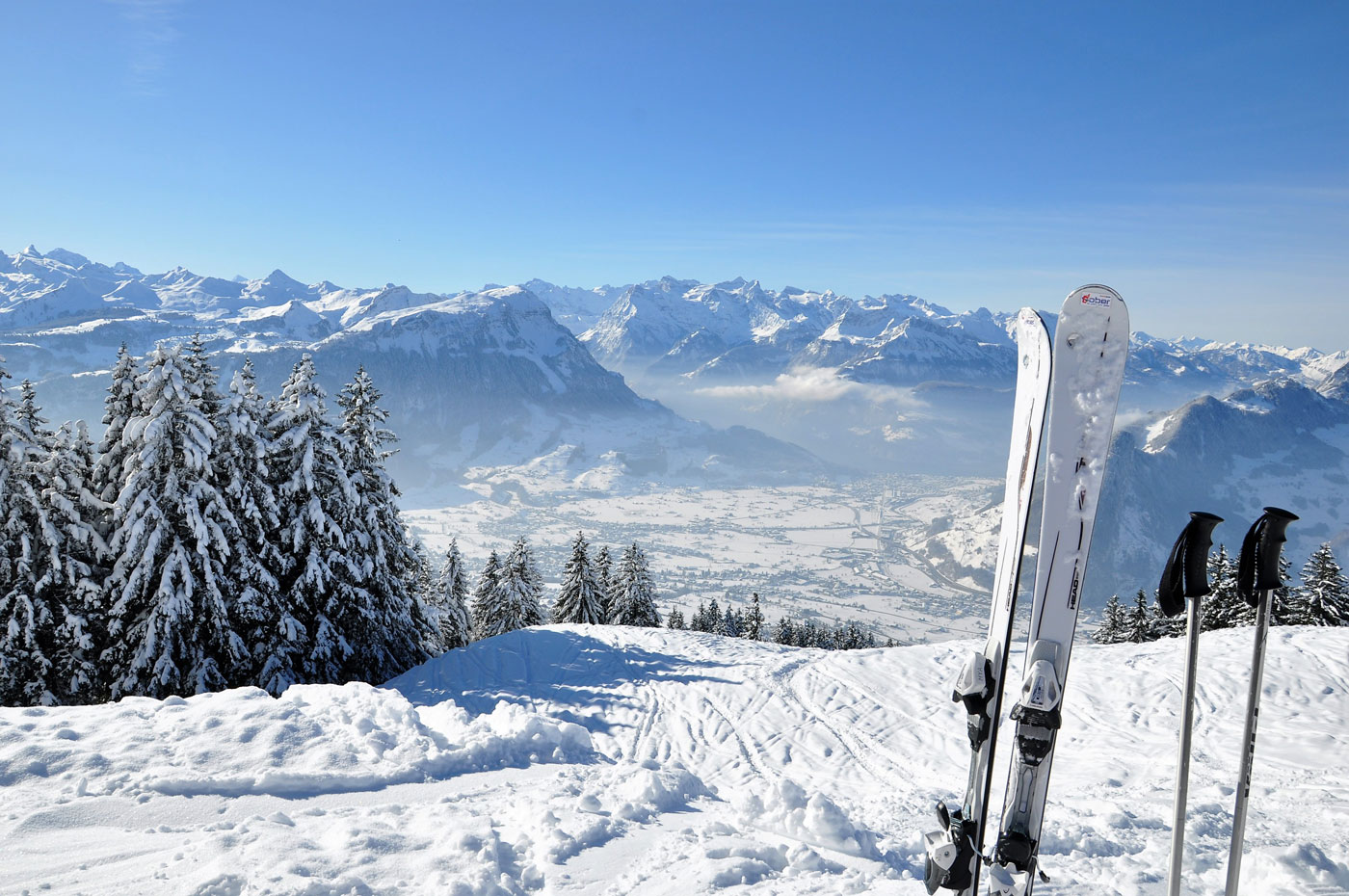 Schöner Wintertag. Blick auf das Tal und die Rigi. Im rechten Bildrand stehen weisse Ski\'s und Stöcke