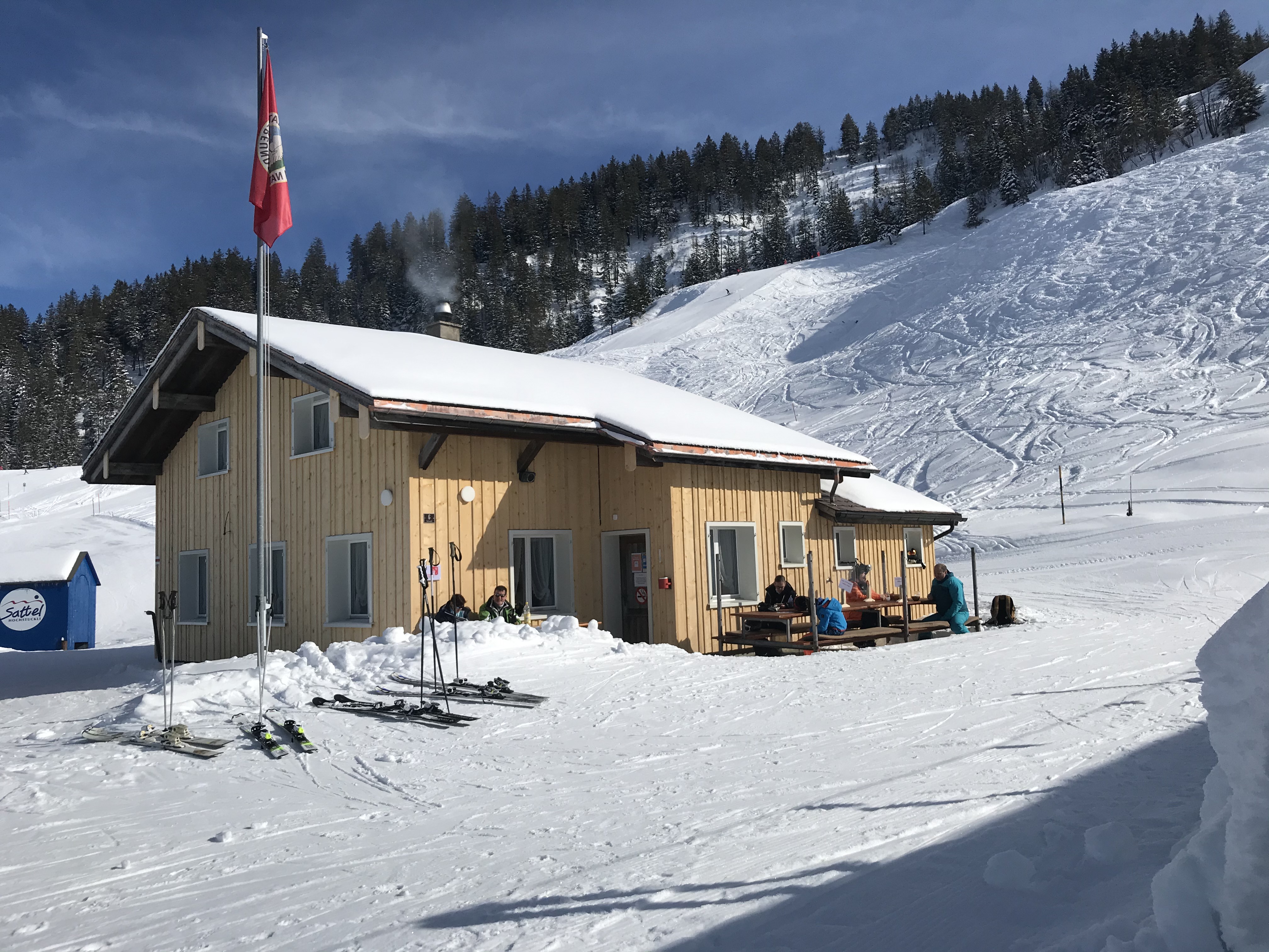 Die Naturfreunde Hütte in hellem Braun im Winter.